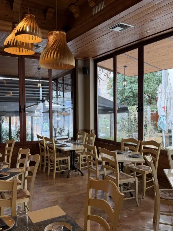Η σάλα της Οδού Ονείρων με τα ξύλινα τραπέζια και τα μεγάλα παράθυρα